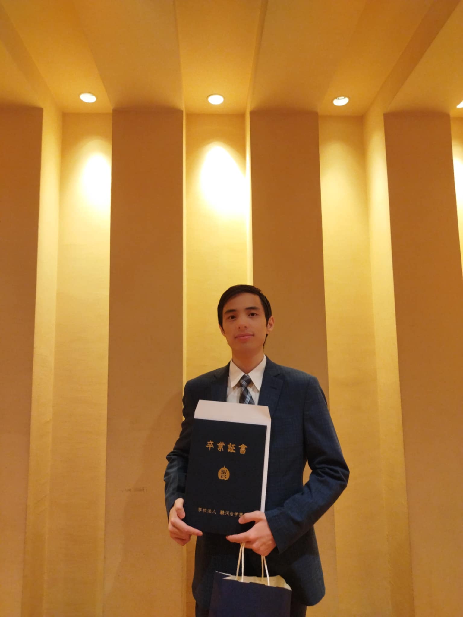 Graduation ceremony, holding my diploma from Sundai IT & Business College